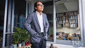 今年是葉浩返台後的第18年。圖為葉浩站在自家陽台，窗內是他的部分藏書。