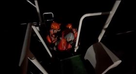 空軍直升機吊籃故障卡在半空，謝沛勳卻卡在半空中無法升降，兩人跳海後才被海巡艇救起。（圖／翻攝畫面）