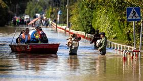 波蘭消防員15日以船隻協助民眾和寵物疏散。（圖／路透社／達志影像）