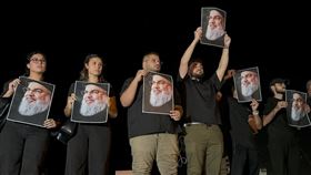 以色列空襲貝斃黎真主黨領袖納斯拉勒，許多支持者手持納斯拉勒哀悼。（圖／路透社／達志影像）