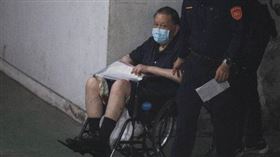 沈慶京住院2週後首次提訊，坐輪椅還看向鏡頭。（圖／鏡週刊）