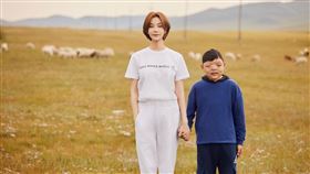 蔡淑臻在大草原緊牽著12歲的蒙古唇腭裂男孩。（圖／羅慧夫顱顏基金會提供）