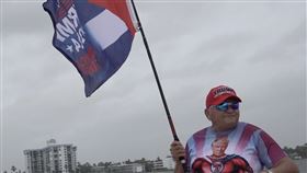 佛州川粉佛羅里達州川粉5日在「海湖俱樂部」外的大橋聚集，除朝往來車輛揮舞寫有「川普」、「奪回美國」的大旗，也身穿「川普鋼鐵人」圖像的T恤。中央社記者鍾佑貞棕櫚灘攝 113年11月6日