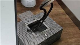 無毒紅斑蛇誤觸鳥網受困，消防員將牠放至籠內帶回，再使用刀具協助脫困並野放。　圖／翻攝自新北市動保處