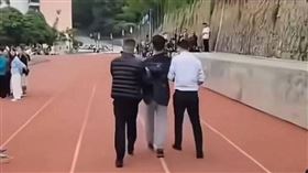 ▲學生上台嗆校方「有錢建魚塘沒錢修宿舍」，隨後遭拉下帶走。（圖／翻攝自微博）