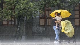 北市午後大雨（3）午後對流雲系發展旺盛，大雨範圍持續擴大到全台16縣市，台北松山文創園區23日下午也出現不小雨勢，有民眾撐傘抱著孩子、推著推車冒雨前行。中央社記者鄭清元攝  113年8月23日