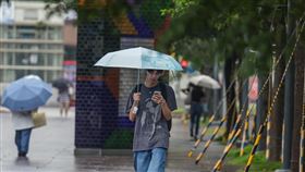 天氣不穩定  午後各地留意大雷雨（2）對流雲系發展旺盛，易有短延時強降雨，中央氣象署15日上午發布台灣本島19縣市大雨特報。圖為台北市信義區外出民眾撐傘遮雨。中央社記者裴禛攝  113年8月15日
