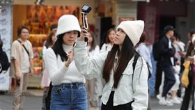 北部整天偏涼氣象署觀測，7日清晨各地低溫約攝氏18至21度，白天北部、東半部及澎湖、金門、馬祖高溫約22至25度，整天偏涼。圖為民眾穿著長袖衣物、戴帽子在台北市西門町商圈取景拍照。中央社記者謝佳璋攝  113年11月7日