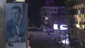 圖為敘利亞大馬士革街道7日空蕩蕩的景象，路邊建築物牆上懸掛敘利亞總統阿塞德肖像的巨型布條。（圖／美聯社／達志影像）