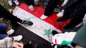 執政超過半世紀的敘利亞阿塞德政權快速垮台。圖為敘利亞民眾踩踏敘利亞國旗。（圖／路透社／達志影像）