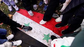 執政超過半世紀的敘利亞阿塞德政權快速垮台。圖為敘利亞民眾踩踏敘利亞國旗。（圖／路透社／達志影像）