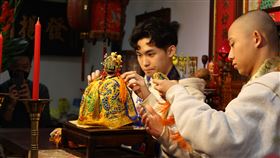 ▲祖師爺冬季換袍大典由國立臺灣戲曲學院學生秦朗(左)與余銘賢(右)為祖師爺換袍（圖／國立臺灣戲曲學院提供）