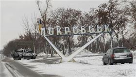 一輛烏克蘭坦克和一輛汽車停在路標附近，路標上寫著「波克羅夫斯克」。(圖/路透/達志)