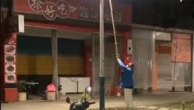 曹婦因不明原因持棍棒在街頭上亂晃。（圖／翻攝畫面）