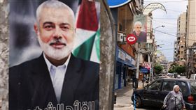 哈瑪斯前領導人哈尼雅在7月被擊斃。圖為一名婦女走過哈尼雅的紀念海報。（圖／路透社／達志影像）