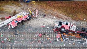 美國佛羅里達州發生嚴重交通事故，一台消防車強行穿越平交道，遭行駛中的高速列車攔腰撞上，撞擊力道之大，導致整輛消防車瞬間翻覆，車體被撞爛，共造成15人受傷。（圖／達志／路透社）