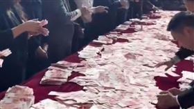 老闆在桌上灑千萬現金讓員工數對金額就拿回家（圖／翻攝微博）