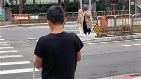 男孩在寒冷的台北街頭僅穿簡單的短袖、短褲，與前方穿大衣的女子形成強烈對比。（圖／翻攝自爆廢公社）