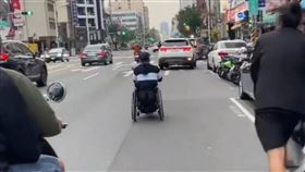 高雄一名男子坐著電動輪椅，在馬路上一路狂飆超越機車。（圖／翻攝社會事新聞影音）