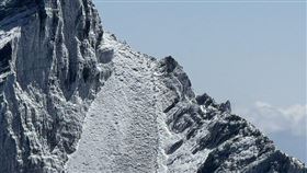 玉山主峰線22日上午發生2名山友墜谷意外，南投縣消防局等單位獲報動員搜救，傍晚時發現2人身影，但因山勢陡峭，需待23日天亮先評估環境後，再搬運至平坦處吊掛下山。（圖/消防提供）