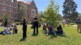 美國佛州州立大學驚傳校園槍擊案，傷患人數不明，學生們在校園內等待消息。（圖／美聯社／達志影像）