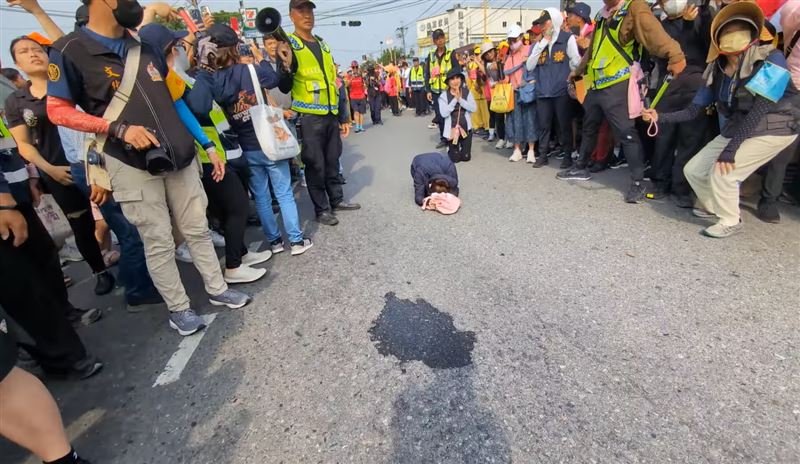 婦人連續磕頭20多下,用力過猛導致額頭滲血,被廟方人員一把扶起。(圖/翻攝自白沙屯媽祖網路電視台YT)