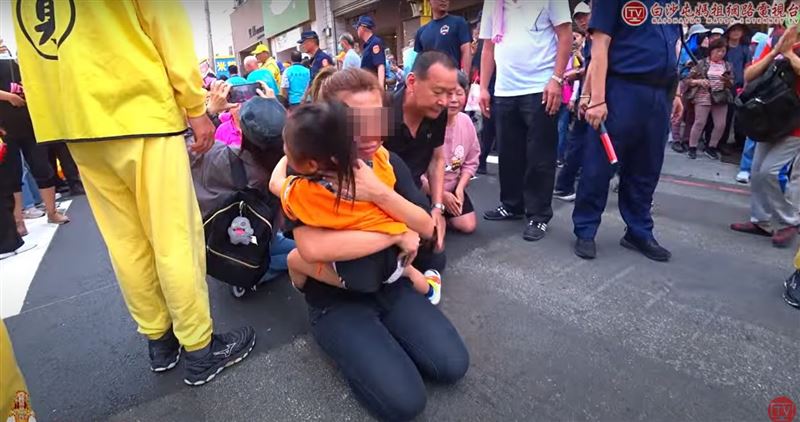 白沙屯媽祖回鑾經過彰化秀水，一名媽媽抱著4歲女兒跪拜鑽轎底，淚求白沙屯媽祖庇佑。(圖／翻攝自白沙屯媽祖網路電視台YT)