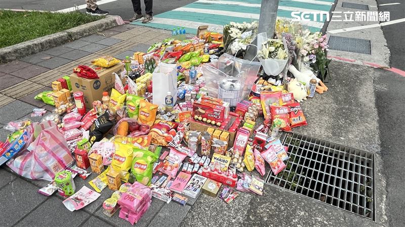 事發現場滿是花束與零食，場面十分哀戚。（圖／記者黃翎瑄攝）