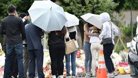 ▲死者家屬身穿素服、撐著雨傘，神情哀戚，腳步沉重。（鏡報新聞網提供）