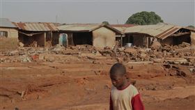 奈及利亞尼日州（Niger State）莫克瓦鎮（Mokwa）遭洪患侵襲，圖為莫克瓦鎮一名男孩走過剛被暴雨沖刷的地方。（圖／美聯社／達志影像）