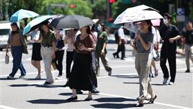 午後防高溫  台北民眾撐傘防曬中央氣象署11日發布高溫資訊，東南風沉降影響，天氣高溫炎熱，白天台北市為黃色燈號，防攝氏36度以上高溫。圖為台北市信義區民眾撐傘防曬。中央社記者張新偉攝  114年6月11日