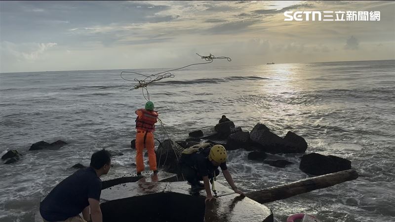 陳男與友人相約到台南黃金海岸戲水,不慎重心不穩落水緊抓消波塊求援。(圖/翻攝畫面)