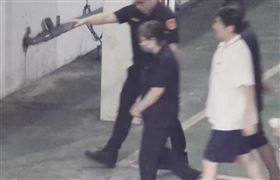 ▲黃呂錦茹走下囚車，聽到車道外媒體喊話提問，看了車道大門一眼。（圖／翻攝畫面）