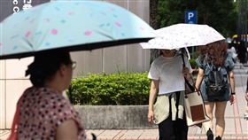 4縣市亮高溫黃燈（1）中央氣象署14日下午發布高溫資訊，西南風沉降影響，天氣高溫炎熱，中午前後台北市、新北市、雲林縣、台東縣為黃色燈號，防攝氏36度以上高溫。圖為台北市南港區民眾撐傘防曬。中央社記者翁睿坤攝  114年6月14日