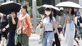 大台北高溫上看逾36度（1）中央氣象署20日發布高溫資訊，大台北等多個縣市防攝氏36度以上高溫，呼籲民眾注意防曬、防中暑。圖為台北市中山區民眾戴帽、撐傘遮陽。中央社記者張皓安攝  114年6月20日