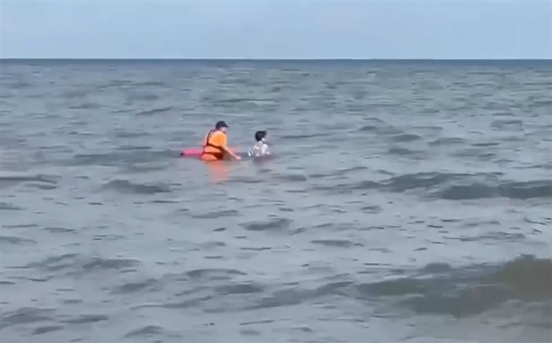 海巡人員緊急將女子拉住,避免遭大浪捲走。(圖/翻攝畫面)