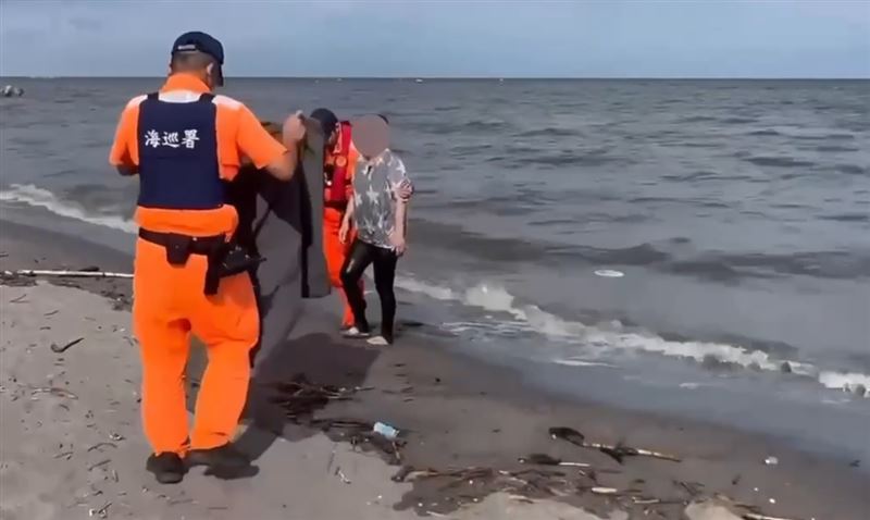 海巡人員緊急將女子拉住,避免遭大浪捲走。(圖/翻攝畫面)
