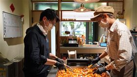 高市青年局長林楷軒（左）走訪「明宏拔絲地瓜」，體驗翻炒拔絲地瓜的製作流程，感受傳統甜食背後的用心與傳承。（圖／高雄市政府青年局提供）