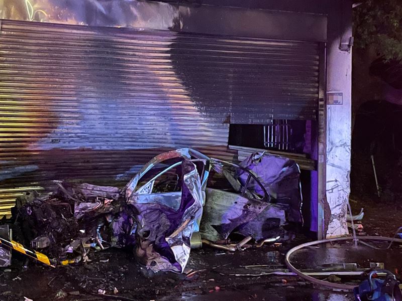 賓士斷成兩截，車頭在民宅中燒成廢鐵，車尾噴飛到車道上。（圖／翻攝畫面）