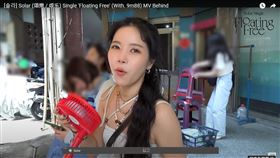 頌樂釋出MV花絮，但是網友目光全被後面拔塑膠椅的工作人員吸引。（圖／翻攝自YouTube）