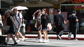 大台北地區高溫炎熱（3）中央氣象署發布高溫資訊，各地天氣持續炎熱，台北市、新北市30日白天為橙色燈號，有連續出現攝氏36度高溫的機率。圖為台北市內湖區民眾戴墨鏡用手遮擋陽光。中央社記者翁睿坤攝  114年6月30日