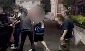 ▲台中豐原5口命案，團購主李女穿著短袖短褲，戴口罩遮臉，移送中檢複訊全程不發一語。（圖／翻攝畫面）