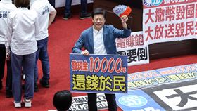 立院拚特別條例三讀　羅明才舉「還錢於民」標語國民黨團11日召開黨團大會，決議處理新台幣4100億元特別條例草案，支持國土韌性的1500億元預算，並納入普發現金1萬元。圖為登記發言時，國民黨立委羅明才（中）拿著鈔票與標語留影。中央社記者翁睿坤攝　114年7月11日