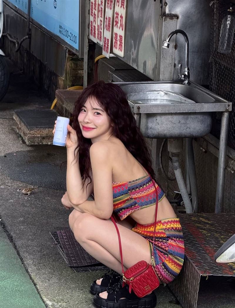 李多慧蹲在水溝蓋旁拍照。(圖/翻攝自李多慧IG)
