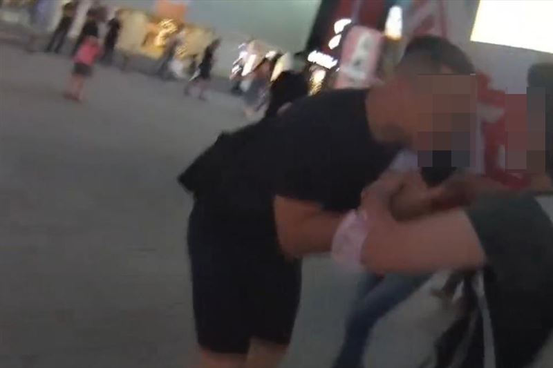 罷團女志工在宣講時,遭身穿黑衣的高姓男子(左)強搶麥克風。(圖/翻攝畫面)