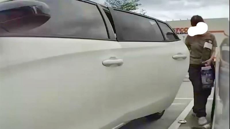 女子將破碎酒瓶踢進特斯拉車底。(圖/翻攝爆料公社公開版)