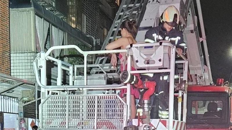 陳女與男友吵架,獨自爬到4樓雨遮,最後被雲梯車救下。(圖/翻攝畫面)