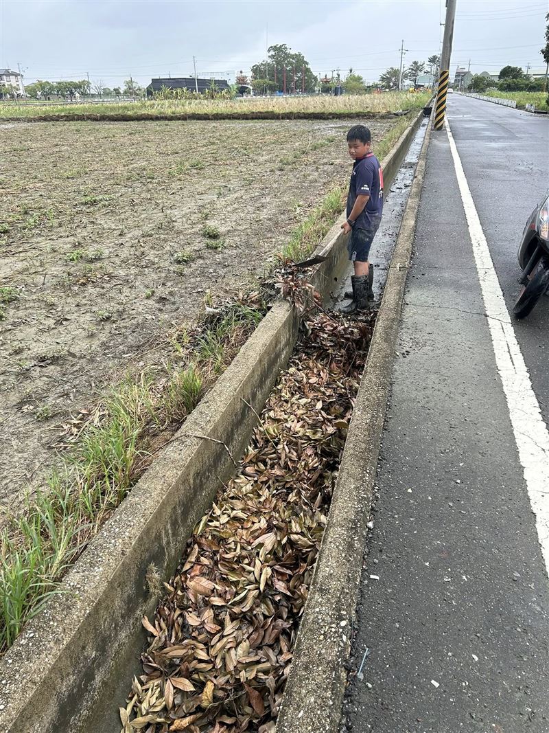 路過民眾拍下台南西港國中吳姓學生默默清水溝的身影。(圖/翻攝自我是西港人臉書)