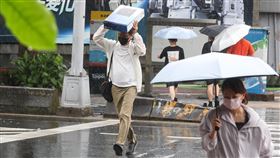台北市區午後降雨中央氣象署17日下午發布大雨特報，因對流發展旺盛，大台北等14縣市防局部大雨。圖為台北市部分行政區午後降雨，街頭民眾未帶雨具，高舉手中物品擋雨、快步前行。中央社記者謝佳璋攝　114年7月17日