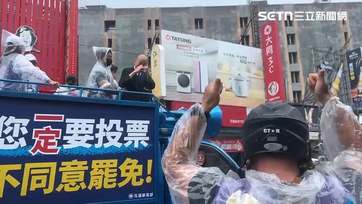 韓國瑜陪傅崐萁車掃遇到民眾嗆聲,比愛心回敬。(圖/翻攝畫面)